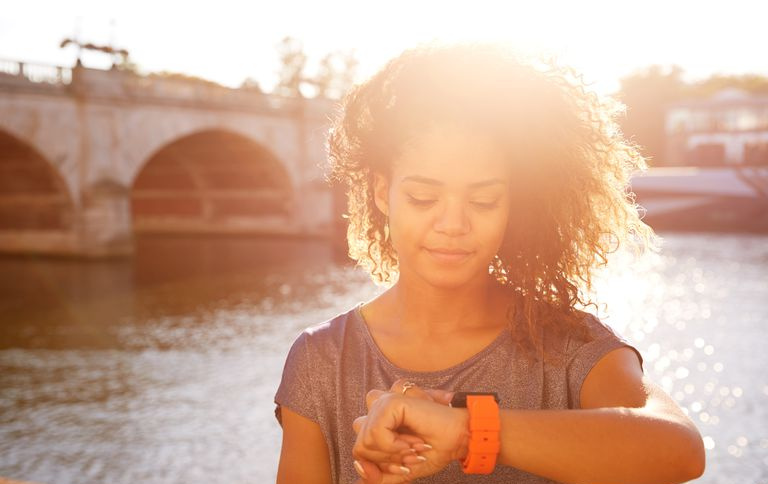 Mujer mirando el reloj junto al río