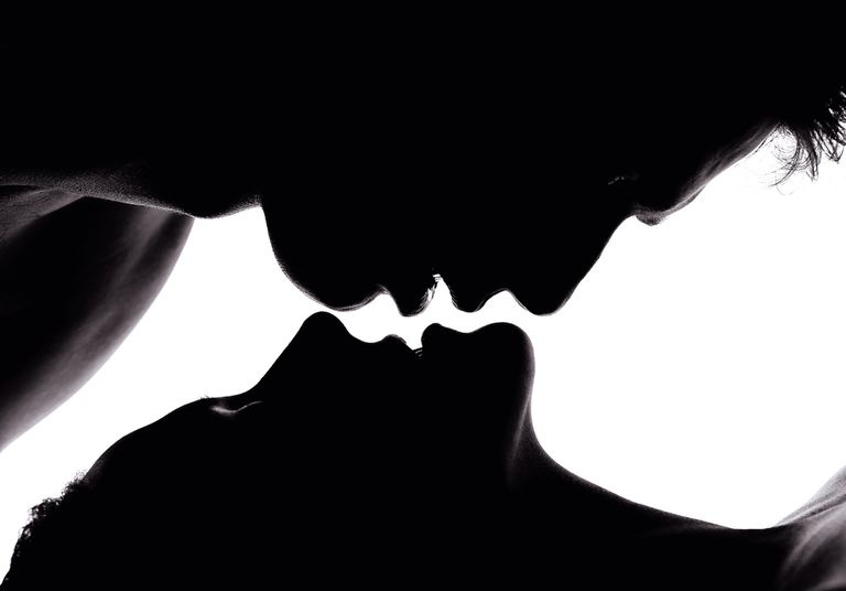 Primer plano de una pareja besándose contra la pared