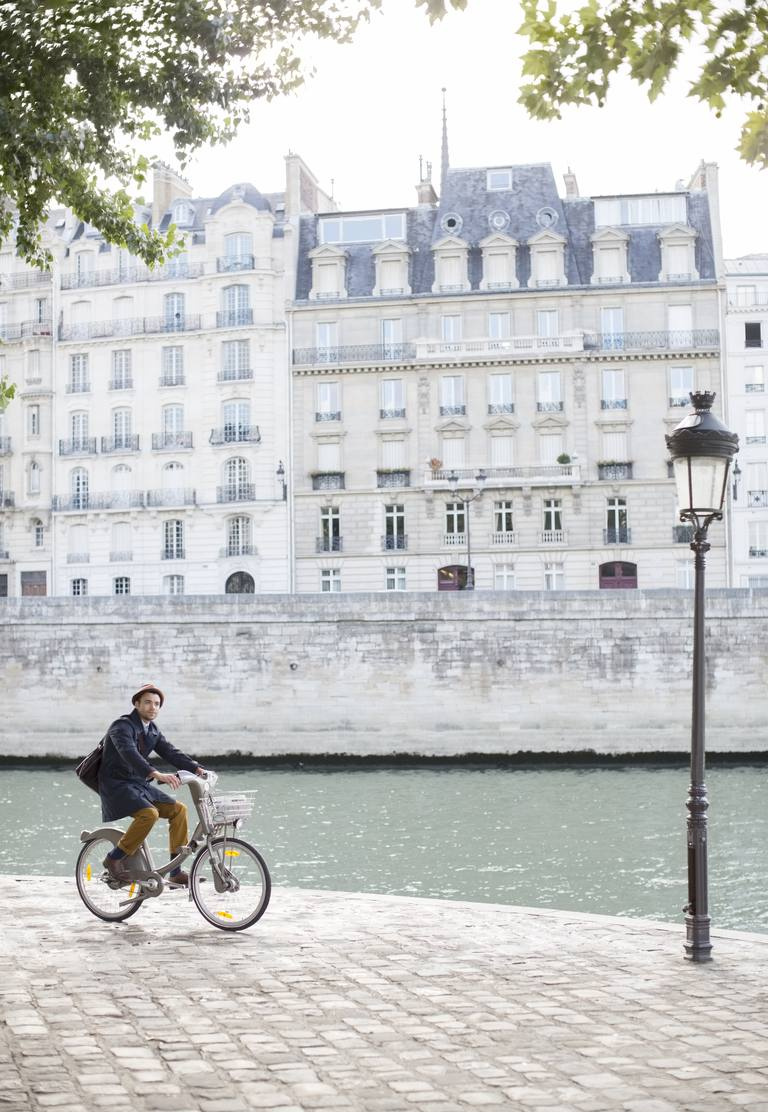 Man riding bicycle le long de la Seine, Paris, France
