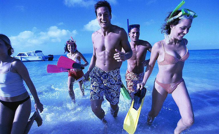 Kunstlichtansicht einer Gruppe von Freunden, die im Wasser rennen