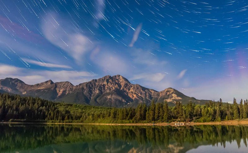 Trilhas de estrelas sobre Patricia Lake e Pyramid Mountain no Jasper National Park, Alberta, Canadá.
