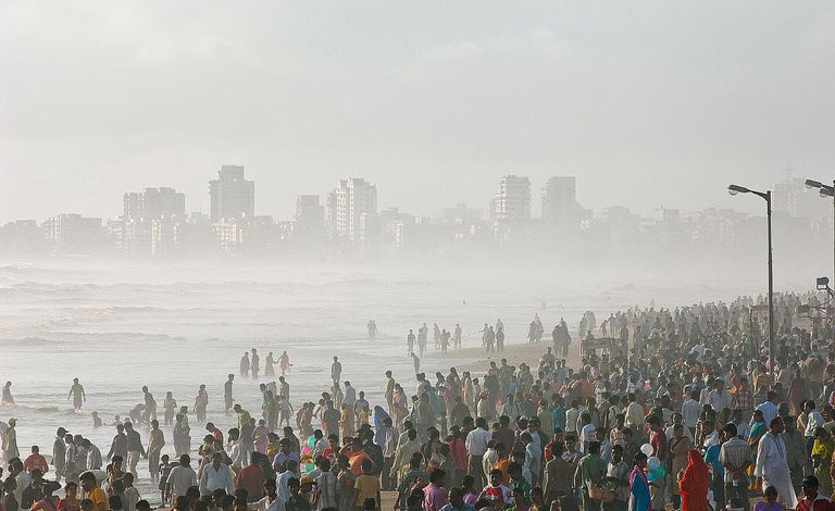 Einheimische aus Mumbai drängen sich am Strand von Juhu, um die ersten Regenfälle des Monsuns zu begrüßen, Mumbai, Maharashtra, Indien