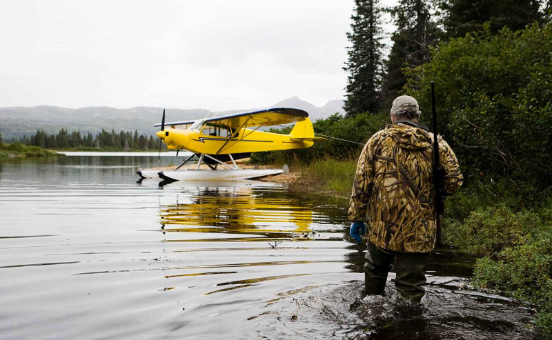 Hunter Wades con su Rife al hombro en el lago Iliamna
