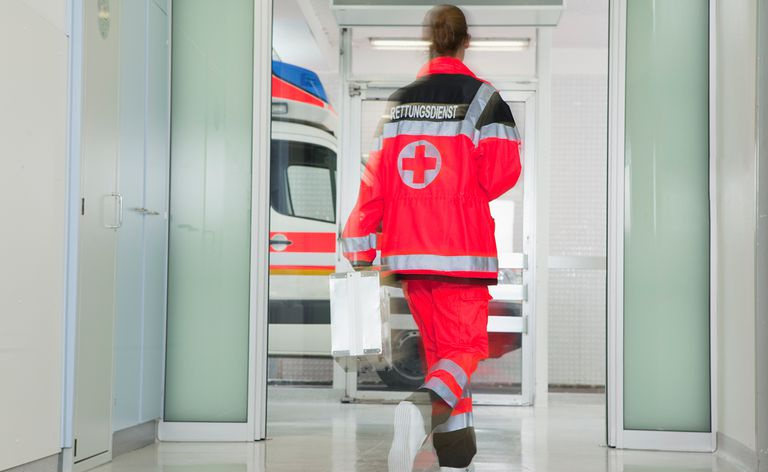 Tył sanitariusza pędzącego w hali