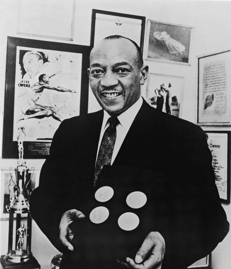 Jesse Owens posa com medalhas de ouro