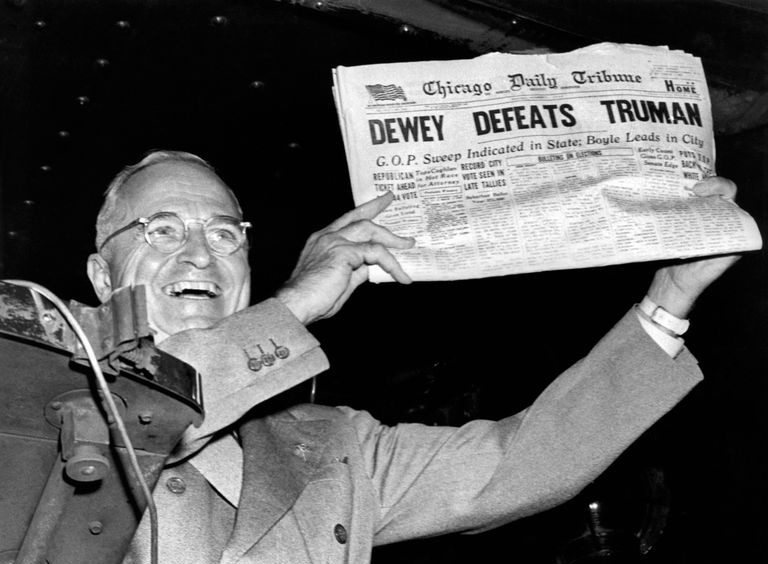 El presidente Harry Truman sostiene un periódico que dice Dewey derrota a Truman.