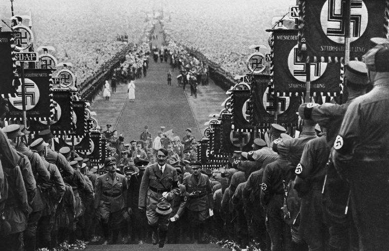 Hitler går i trapper omgitt av nazister med en folkemengde i bakgrunnen