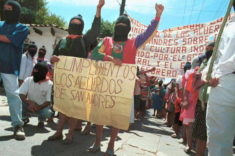 Duas mulheres seguram um cartaz pedindo ao governo que cumpra os Acordos de San Andrés