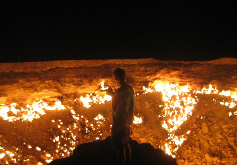 Hombre de pie frente a las Puertas del Infierno, en Derweze, Turkmenistán.
