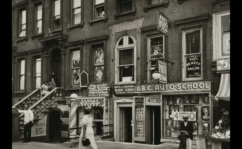Widok na witryny sklepowe na bloku 420 Lenox Avenue, Harlem, Nowy Jork, 14 czerwca 1938. Znajduje się tam salon fryzjerski, szkoła urody, szkoła samochodowa i delikatesy.