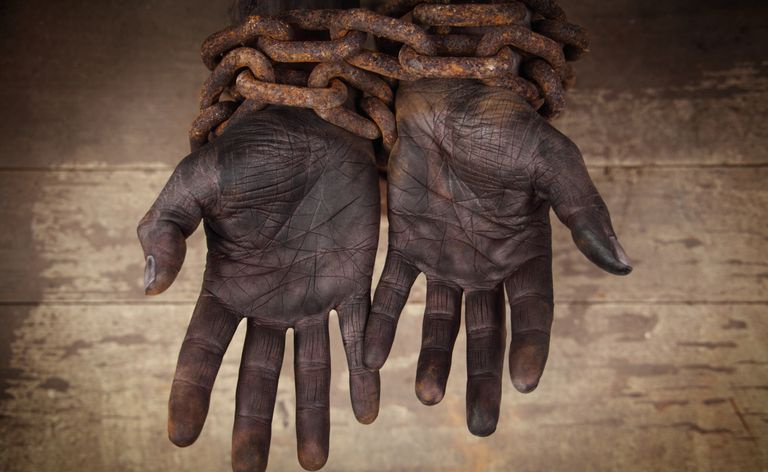 mains noires liées par de lourdes chaînes rouillées