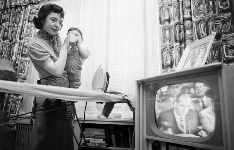 Fotografia di una donna che guarda in TV il senatore Joseph McCarthy
