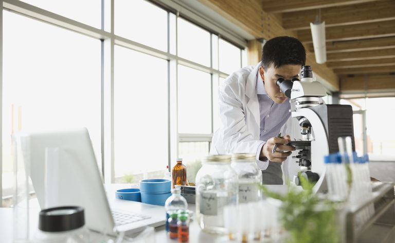 zinātnieks laboratorijā izmanto mikroskopu