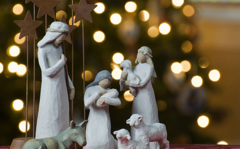 Presepe con luci di Natale sullo sfondo.