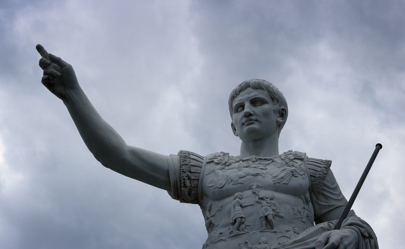Statua di Giulio Cesare contro un cielo tempestoso.