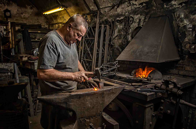 un hombre calentando y trabajando con metal