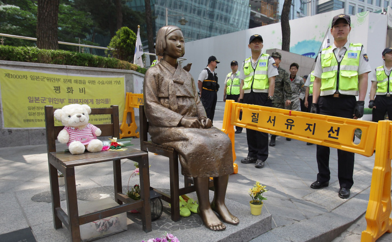 Guardas em volta da estátua da mulher de conforto em Seul, na Coreia do Sul.