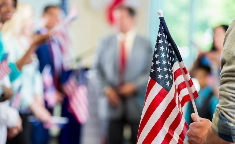 Supportere som vifter med amerikanske flagg på et kampanjemøte