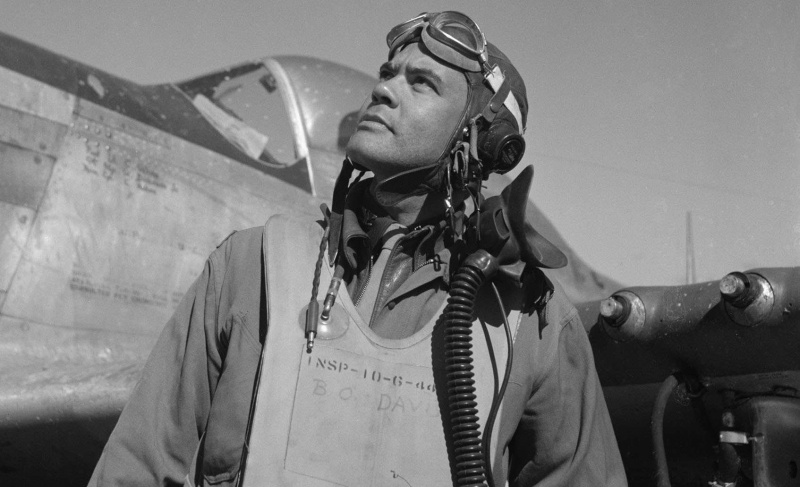 Benjamin O. Davis in Fluganzug und Helm steht vor einem P-51 Mustang-Jäger.