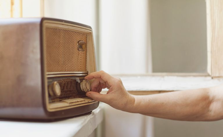 A mulher usa um rádio tradicional velho