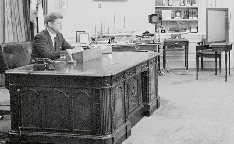 El presidente John F. Kennedy sentado en el escritorio Resolute