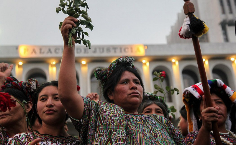 Mujeres ixiles sosteniendo rosas.