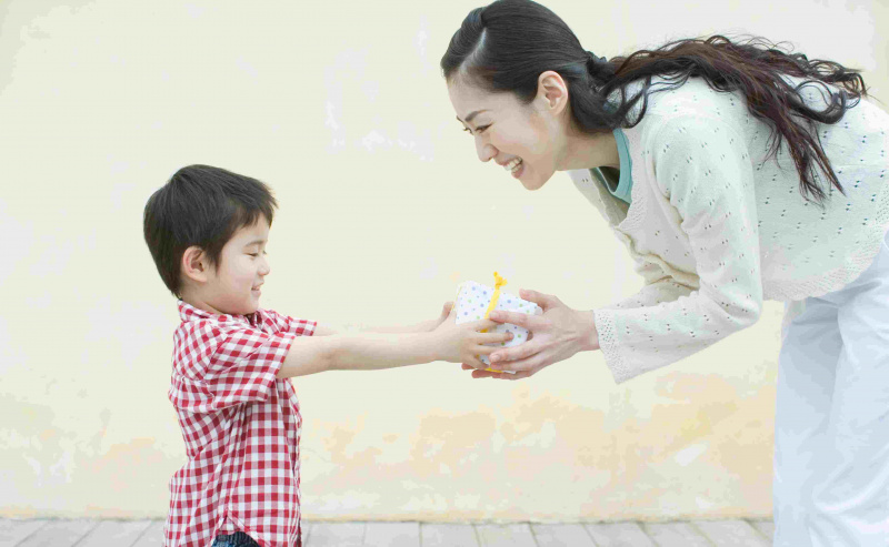 Menino dando um presente para sua mãe