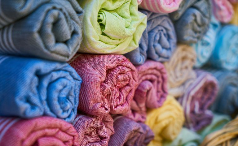 Rotoli di diversi tessuti colorati.