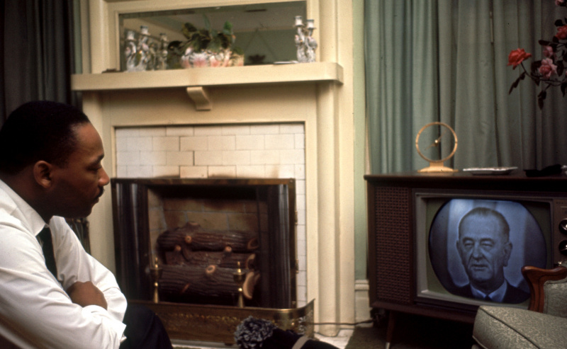 Martin Luther King, Jr. viendo al presidente Lyndon Johnson en la televisión.
