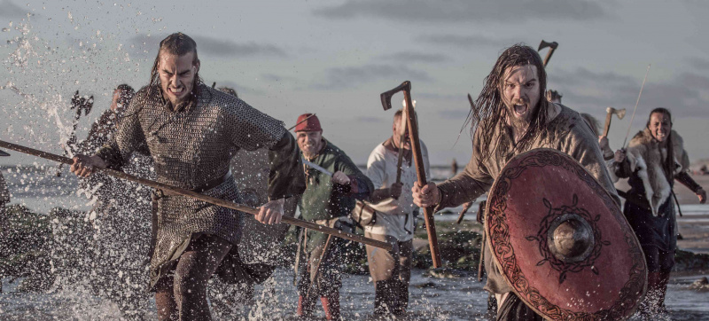 Um tesouro de armas empunhando guerreiros vikings lutando em uma cena de campo de batalha no mar