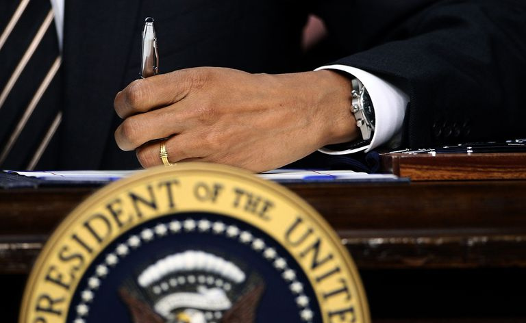 Le président Obama signe le STOCK Act sur le bureau Resolute du bureau ovale