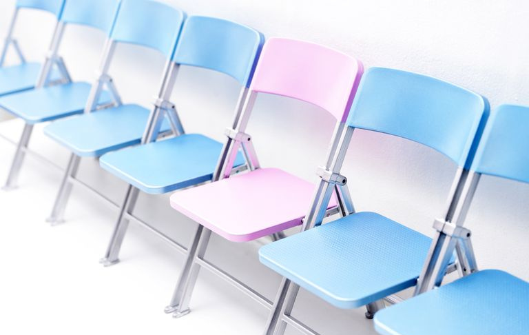 Una silla rosa en una fila de sillas azules