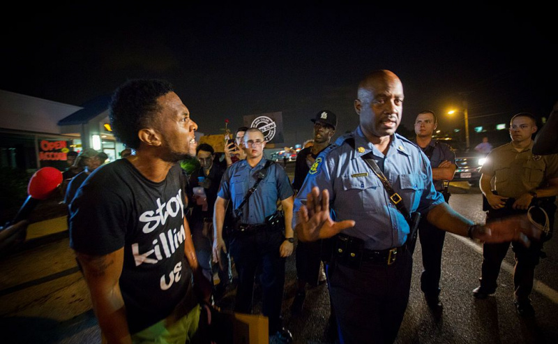 O capitão Ronald Johnson, do Missouri State Trooper, recebe uma orelha cheia de um manifestante