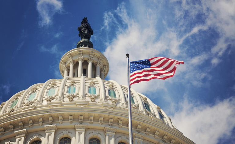 Edificio del Capitolio de los Estados Unidos y bandera estadounidense en Washington, D.C.
