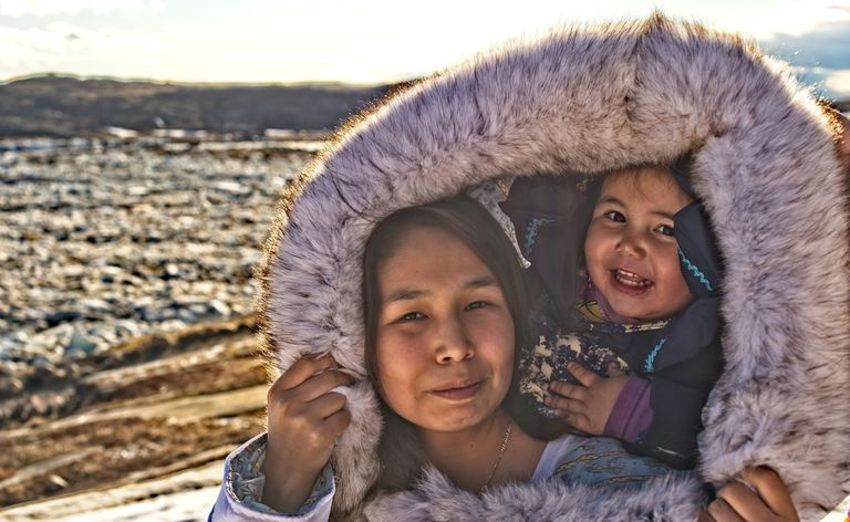 Inuit mor og datter på Baffin Island, Nunavut, Canada, i tradisjonell kjole ute på tundraen.