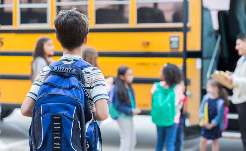 Zēns gaida iekāpšanu skolas autobusā