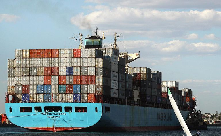 liten seilbåt ved siden av stort containerskip