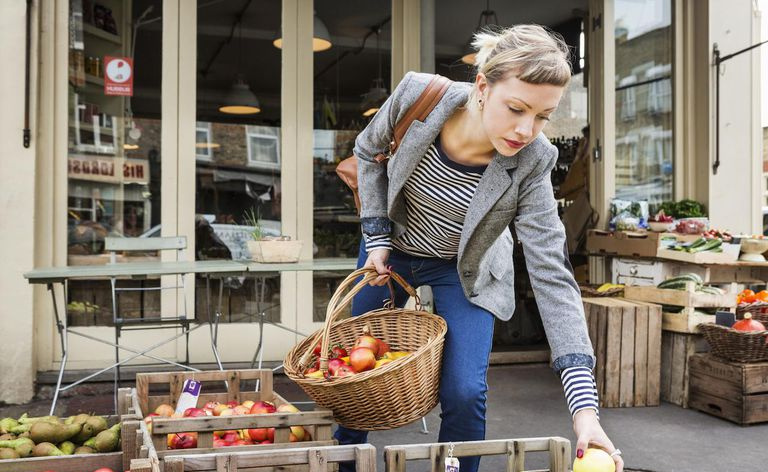 Mulher comprando frutas orgânicas.