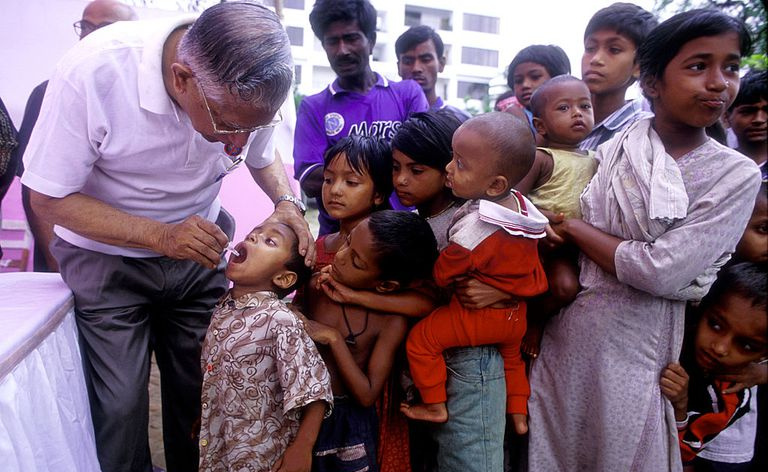 Członek Rotary Club podaje doustną szczepionkę przeciwko polio dzieciom ze slumsów w Dhace 23 kwietnia 2000, podczas Narodowego Dnia Szczepień Polio w Bangladeszu.