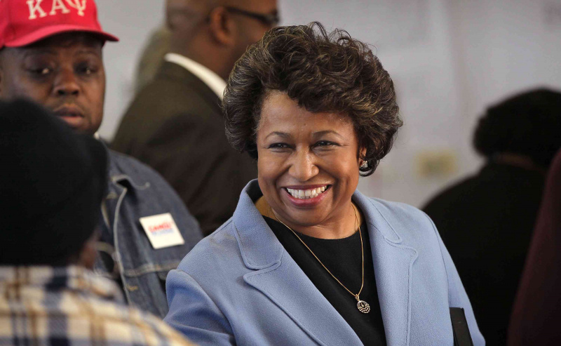 Carol Moseley Braun iført en blå dressjakke og smiler til en mann
