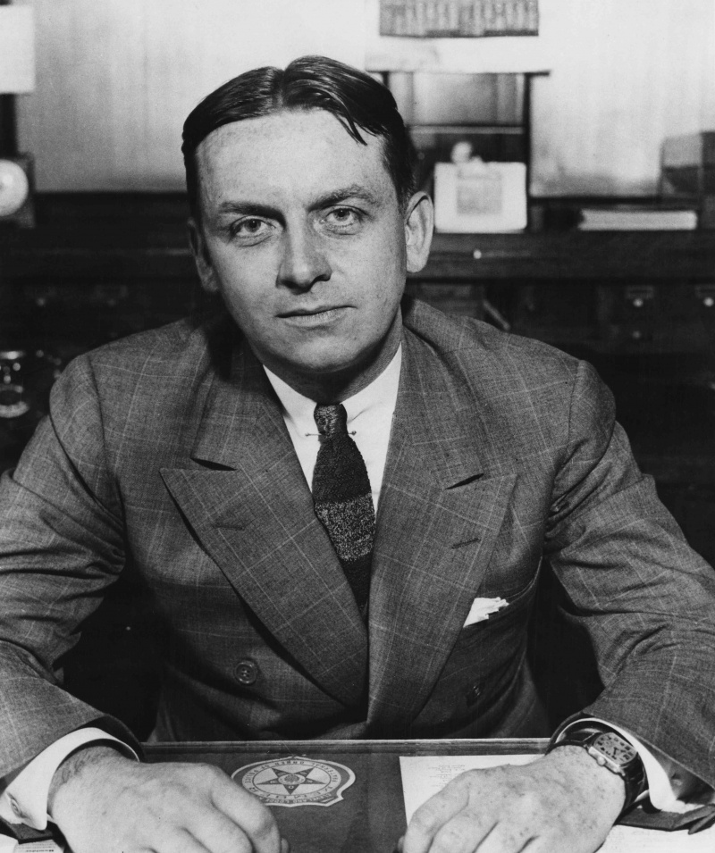 Agente del FBI Eliot Ness sentado en el escritorio, c. 1930.