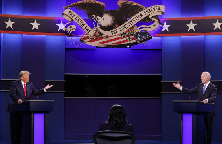 Donald Trump y Joe Biden se paran en podios en extremos opuestos de un escenario de debate