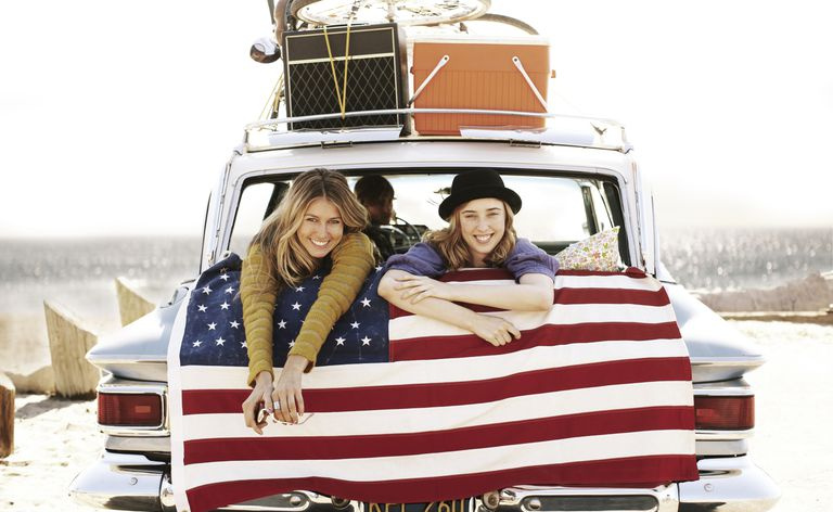 Junge Leute im Auto mit amerikanischer Flagge.