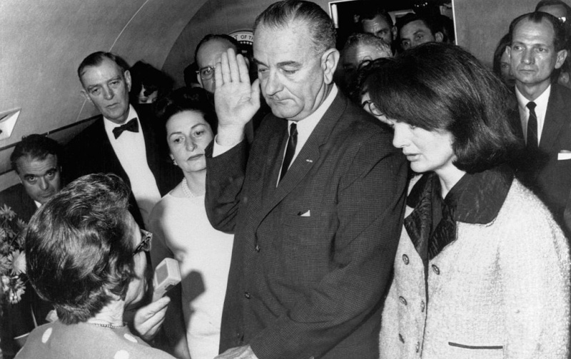 O vice-presidente Lyndon B. Johnson é empossado no escritório da Presidência a bordo do Air Force One em Dallas, Texas, horas após o assassinato do presidente John F. Kennedy.