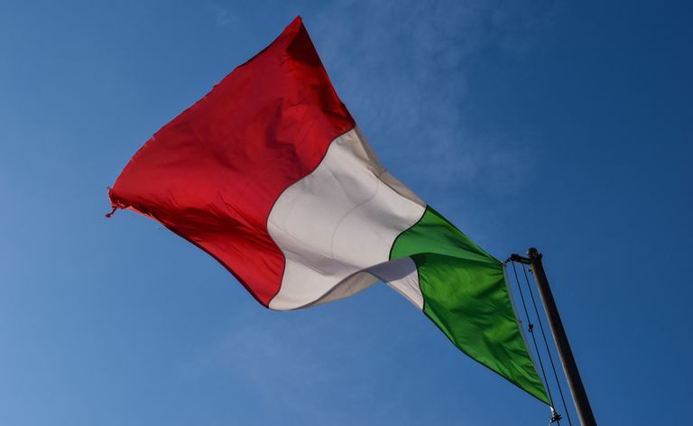 Niski kąt widzenia włoskiej flagi na tle nieba