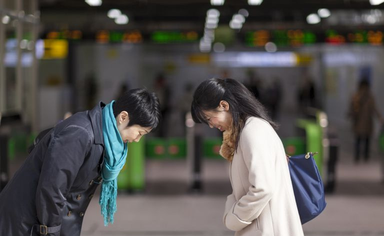 Dve japonski podjetnici, ki se klanjata druga drugi na postaji