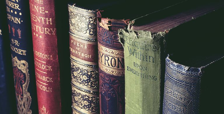 Collection de vieux livres classiques sur une étagère.
