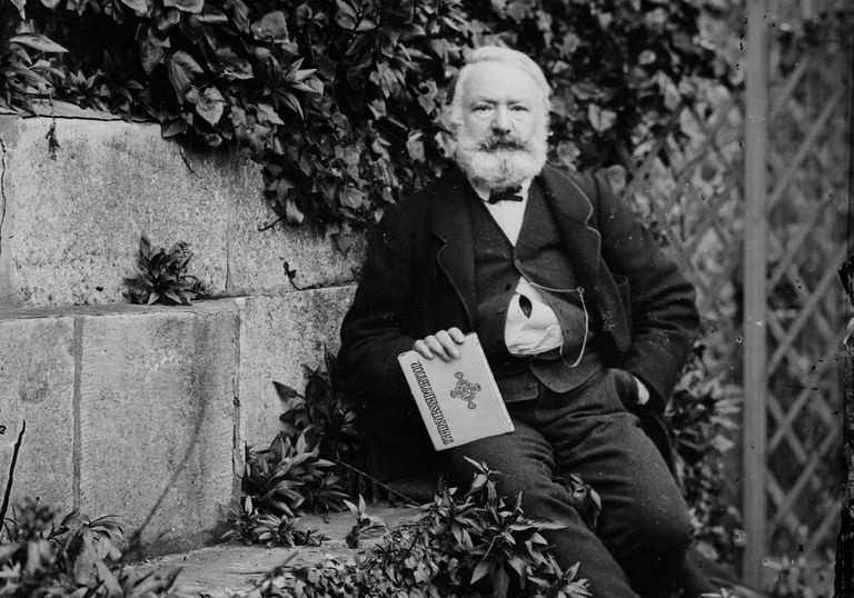 Victor Hugo siedzący na werandzie wśród liści