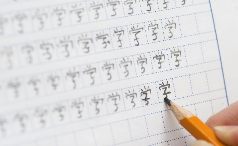 aluno aprendendo a escrever caracteres chineses