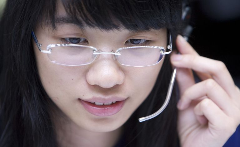 Ung kinesisk kvinne på telefonhodesett